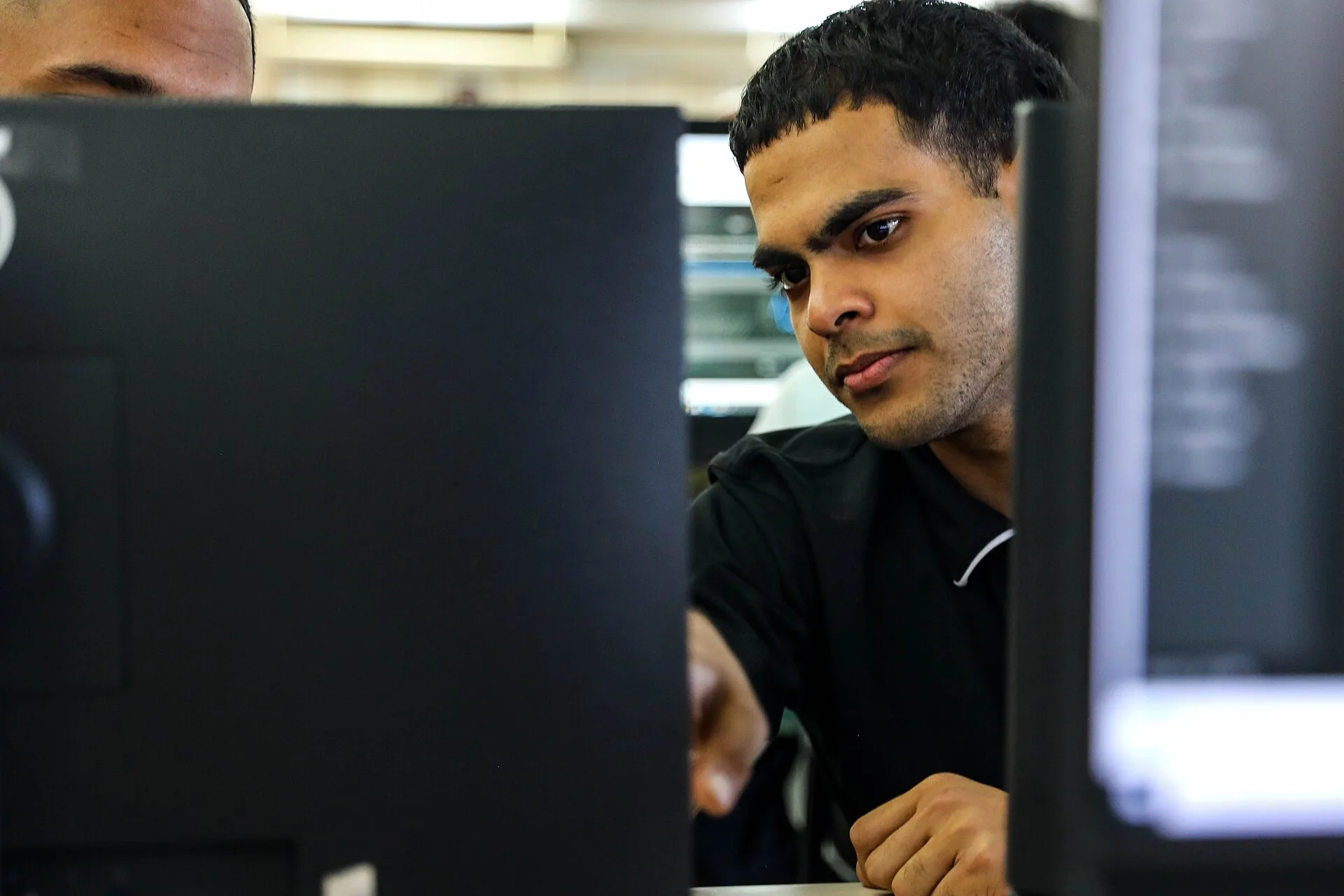 Aaron Singh, cyber security analyst with the Trinidad and Tobago Cyber Security Incident Response Team, works with a multinational team to respond to a simulated cyber attack during the culminating exercise of the cyber training track at TRADEWINDS 25 (TW25) at the University of the West Indies at S