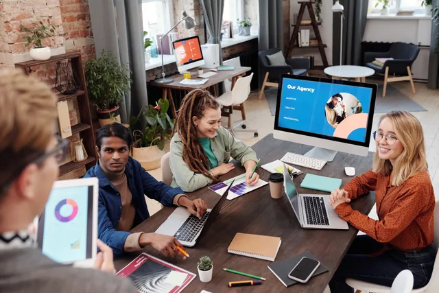 Team of diverse colleagues collaborating on project in modern office with digital devices and charts. A framework for checking England PR agency listings